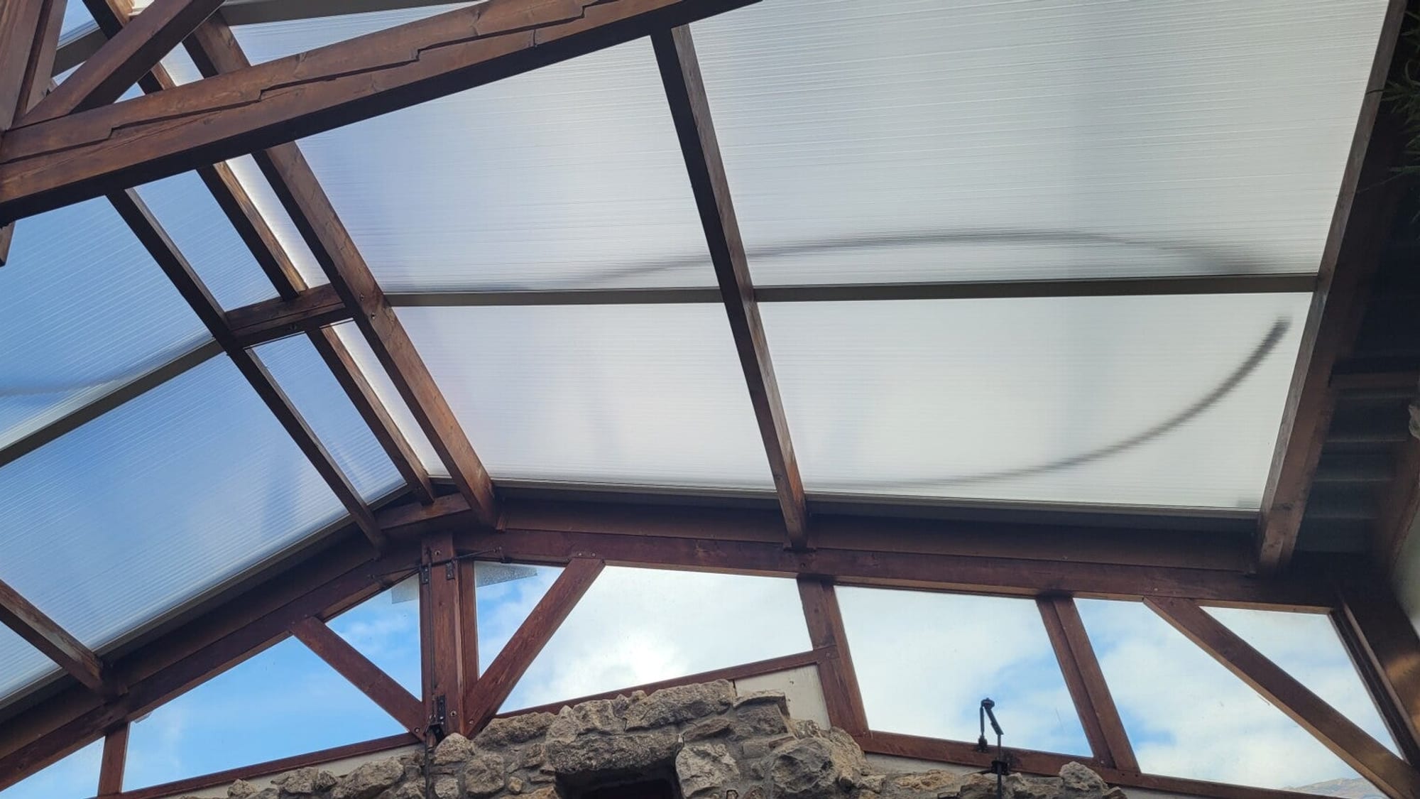 Couverture de terrasse à charpente bois teintée réalisée par FD CONCEPT'