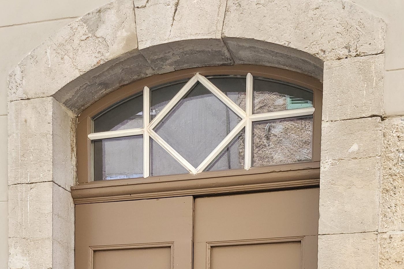Imposte en losange au-dessus d'une porte cochère, encadrement en pierre de taille