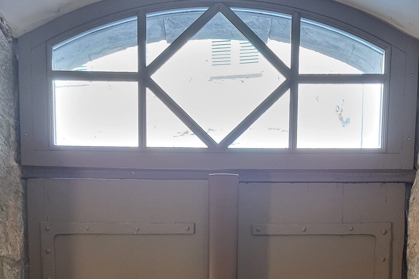 Porte cochère de mas restaurée, vantaux peints gris-taupe à pentures forgées